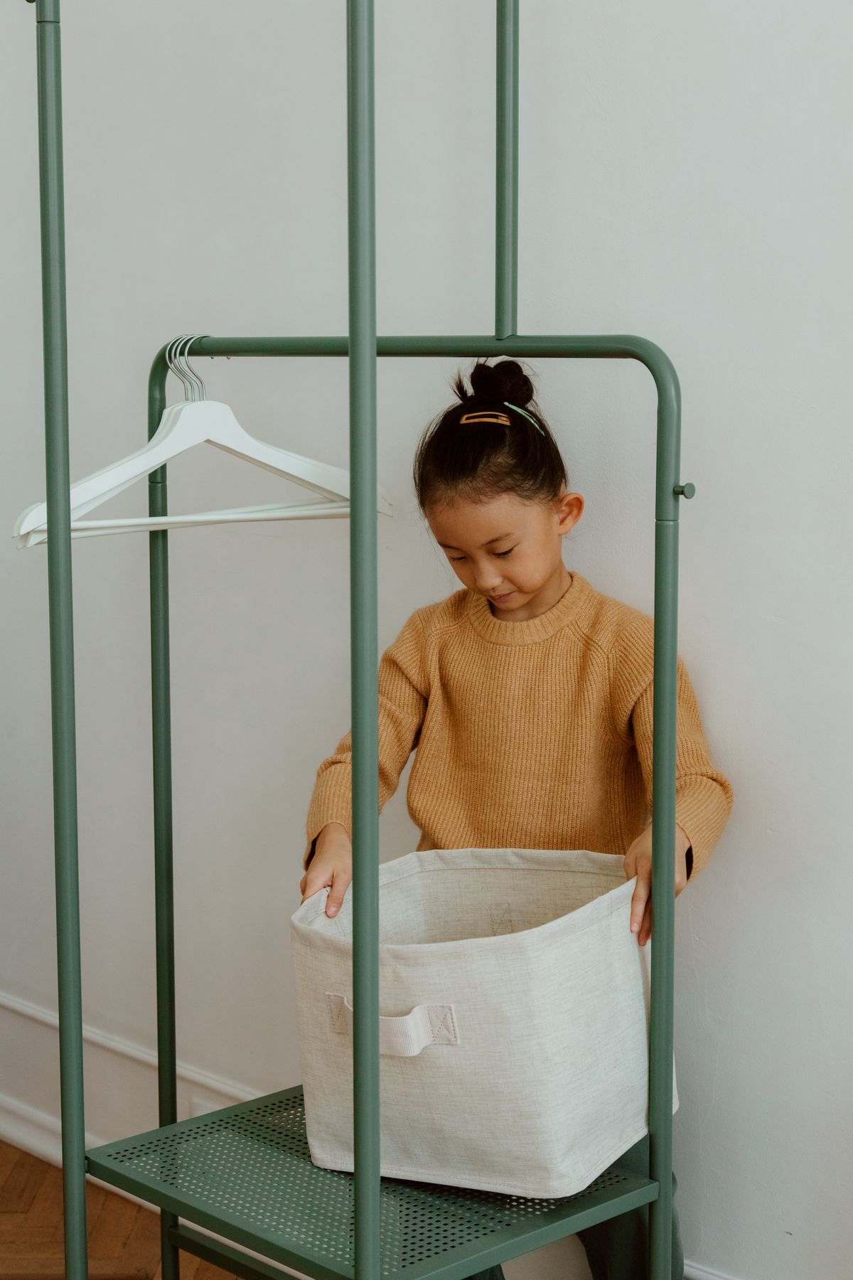 A child placing laundry in a basket.